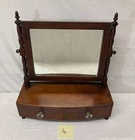 Front view of the antique shaving mirror showing tilting wooden frame, two drawers below, and overall wood finish.