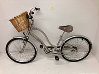 Full side view of silver cruiser bike showing frame, wheels, basket and saddle