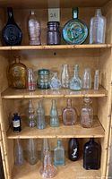 Full lot view on wooden shelving showing four shelves of assorted bottles and jars
