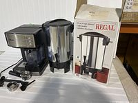 Oster espresso maker with Regal coffee urn and box, showing appliance and packaging.