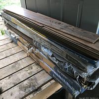 Six boxes of laminate flooring stacked wrapped in plastic showing the Timberland brand and product details.