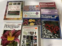 Photo of seven gardening books laid flat with covers visible showing various gardening topics.