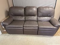 Front view of the brown leather 3-seat sofa with cushioned arms and backrests.