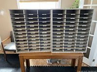 Two large mail slot units side by side showing multiple labeled horizontal compartments for mail sorting.