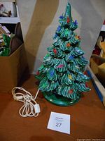 Full view of ceramic Christmas tree with attached electrical cord and switch.