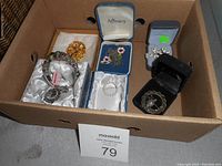 Box containing multiple costume jewelry pieces including necklaces, pins, bracelets in original boxes and loose.