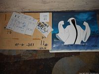 Photo of the front view of the animation cel showing the ghost-like figure alongside the production notes arranged on a surface.