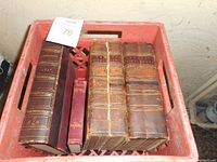 Top-down photo of boxlot showing several antique leatherbound books including two volumes of Johnson's Dictionary and Elsie series books.