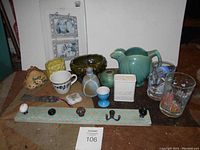Photo of all lot items including vintage ceramic bird pitcher, Disney glasses, salt and pepper shakers, a wooden knob hanger and various small pottery and decorative items.