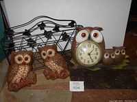 Front view of the owl clock, two owl wall decor pieces and the ivy magazine stand together