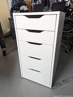 Front view of white Ikea Alex drawer unit with five drawers in a stacked configuration, showing the clean modern style and cut-out handles.