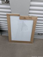 IKEA Kvissle whiteboard, still sealed in original cardboard and plastic wrapping, light wooden frame visible.