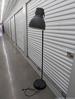 Full view of the large black floor lamp showing its height and slim pole design.