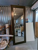 Full view of mirror leaning against storage wall showing overall size and appearance