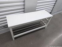 Side view of white shoe rack showing wood frame and metal rod shelves.