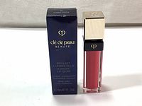 Lip gloss product and original box showing front side with branding and product details