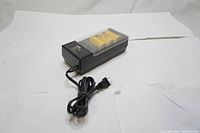 EVEREADY battery charger plugged with power cord visible alongside 4 yellow D size batteries in the charger under transparent cover.