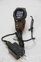 Bushnell Neo iON GPS golf watch with USB charger cable and charging clip shown.
