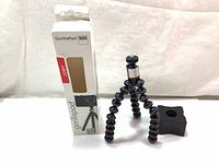 Joby GorillaPod 325 tripod with segmented flexible legs and adjustable ball head, shown next to original retail box with branding and model info.