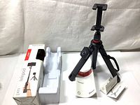 Joby Telepod tripod selfie stick displayed with original packaging and plastic inner tray, showing black tripod folded with phone mount and Bluetooth remote.