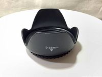 Top view of black plastic 58mm diameter tulip flower petal shaped lens hood showing front flare shield and diameter marking (58mm) with alignment arrow.