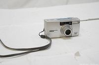 Front view of Pentax Espio 150 SL showing lens extended and wrist strap attached.