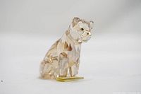 Side angle showing sitting lion cub figurine in rose gold crystal with faceted cuts reflecting light.