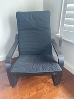 Front view of IKEA bentwood armchair with black cushion, showing overall structure and cushion condition including slight dust.