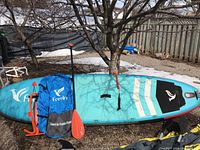 Full view of paddle board with paddle, pump and carry bag