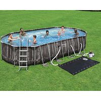 Assembled pool on grass with attached sand filter pump, ladder and solar mat visible