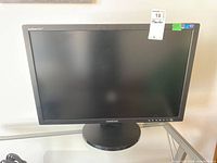 Front view of the Samsung SyncMaster 275T Plus monitor showing the screen, base stand, and some buttons on the bottom right bezel.
