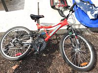 Full side view of red Supercycle bicycle showing frame, wheels and drivetrain.