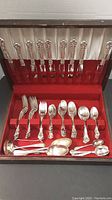 Fitted box open showing flatware set with knives, forks, spoons arranged.