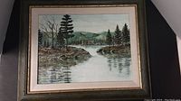 Framed acrylic painting of a wooded landscape with river and hills in the background.