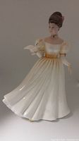 Front view of the Kathleen HN 3609 Royal Doulton porcelain figurine showing cream dress and dove on arm.