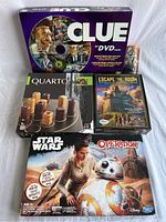 Overview photo showing all five board games including Clue DVD game, Quarto, Escape the Room, Star Wars Operation, and another Escape Room title.