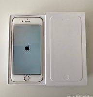 iPhone 6 powered on displaying Apple logo in original box with box lid beside it