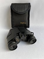 Magnicon Featherweight binoculars with carrying case, showing binoculars front and case upright behind.