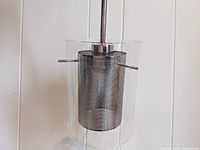 Pendant light featuring chrome finish with steel mesh and intact clear glass cylinder