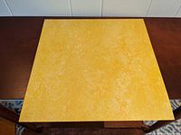 Top side view of a lemon yellow Marmoleum linoleum tile with light marbling.