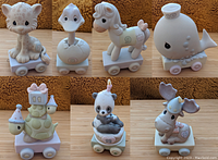 Seven Precious Moments Birthday Train figurines displayed in a row, each with pastel colors, animal figures on wheeled bases, numbered 7 to 13