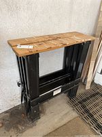 Folded Harbor Freight Tools sawhorse with metal legs and wood top, showing general condition.
