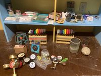 Overview of the lot showing colorful handle hex key sets, multiple gauges including brass and metal ones, and various small boxed items on a shelf.