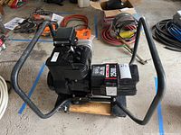 Top-down angled photo of the Homelite generator on the dolly showing the engine, frame and surrounding garage floor context.