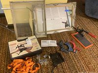 Overview photo of all items including Picture Framing Kit case, clamps, orange ratchet straps, mirror, and framed glass panel.