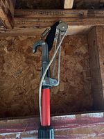 Photo of Corona pole pruner with metal blade and pulley, attached to orange pole