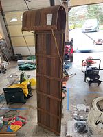 Photo of full wooden toboggan showing top curved section and long wooden slats with metal brackets