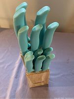 Full view of 12 knives with turquoise handles in wooden block