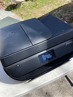 Photo showing the top and front of the black HP Officejet 4650 printer with power button and touchscreen display.