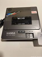 Front view showing brand, tape window and controls of the HANNA VHS/Beta tape rewinder and eraser unit.